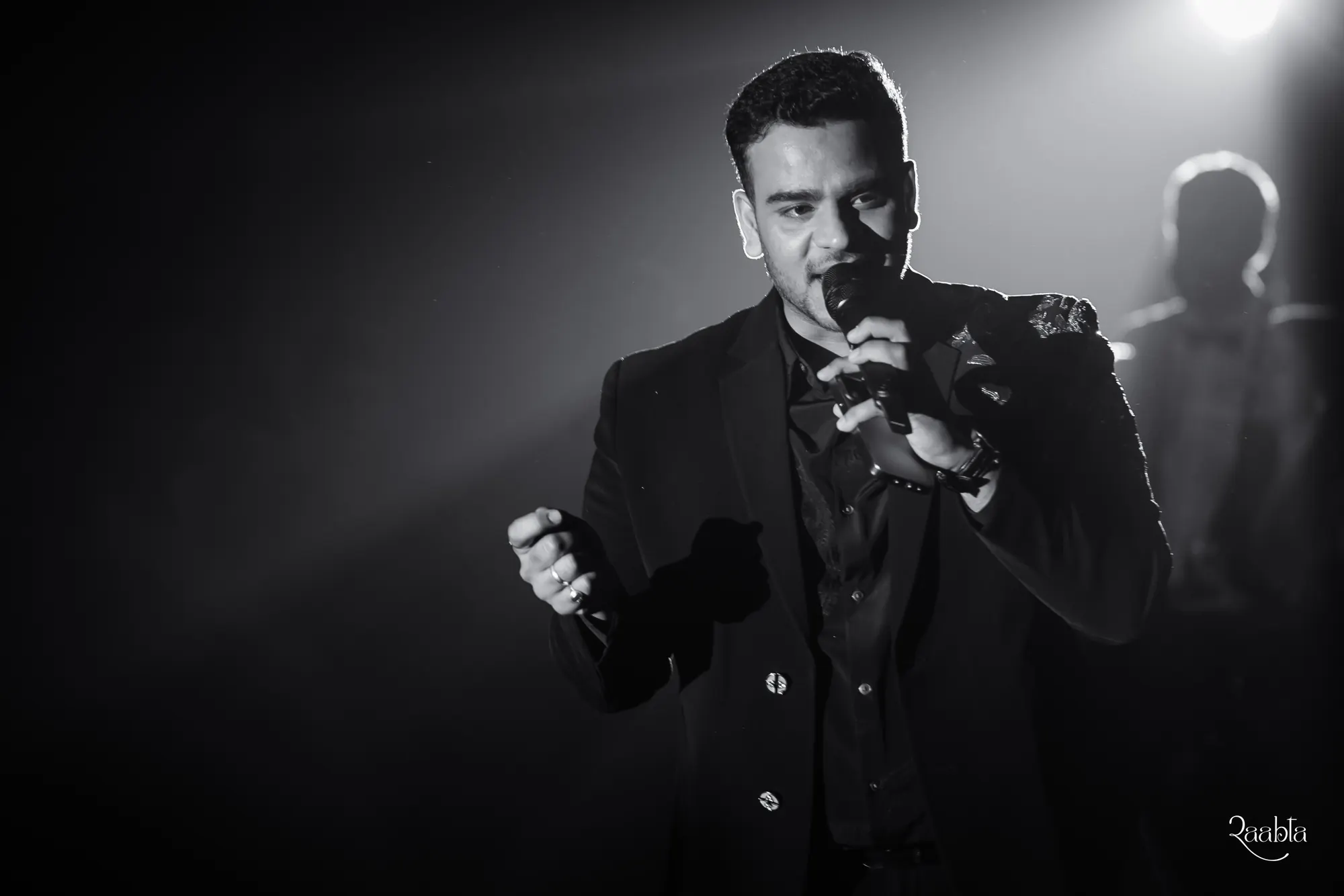 Black and white photograph of Chirag singing at Shiven and Palak's wedding, Bahrain