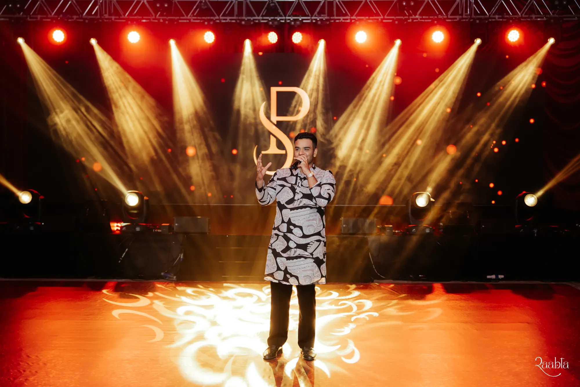 Chirag Vithalani alone on a gold-lit stage at Shiven and Palak's wedding, Sofitel Bahrain