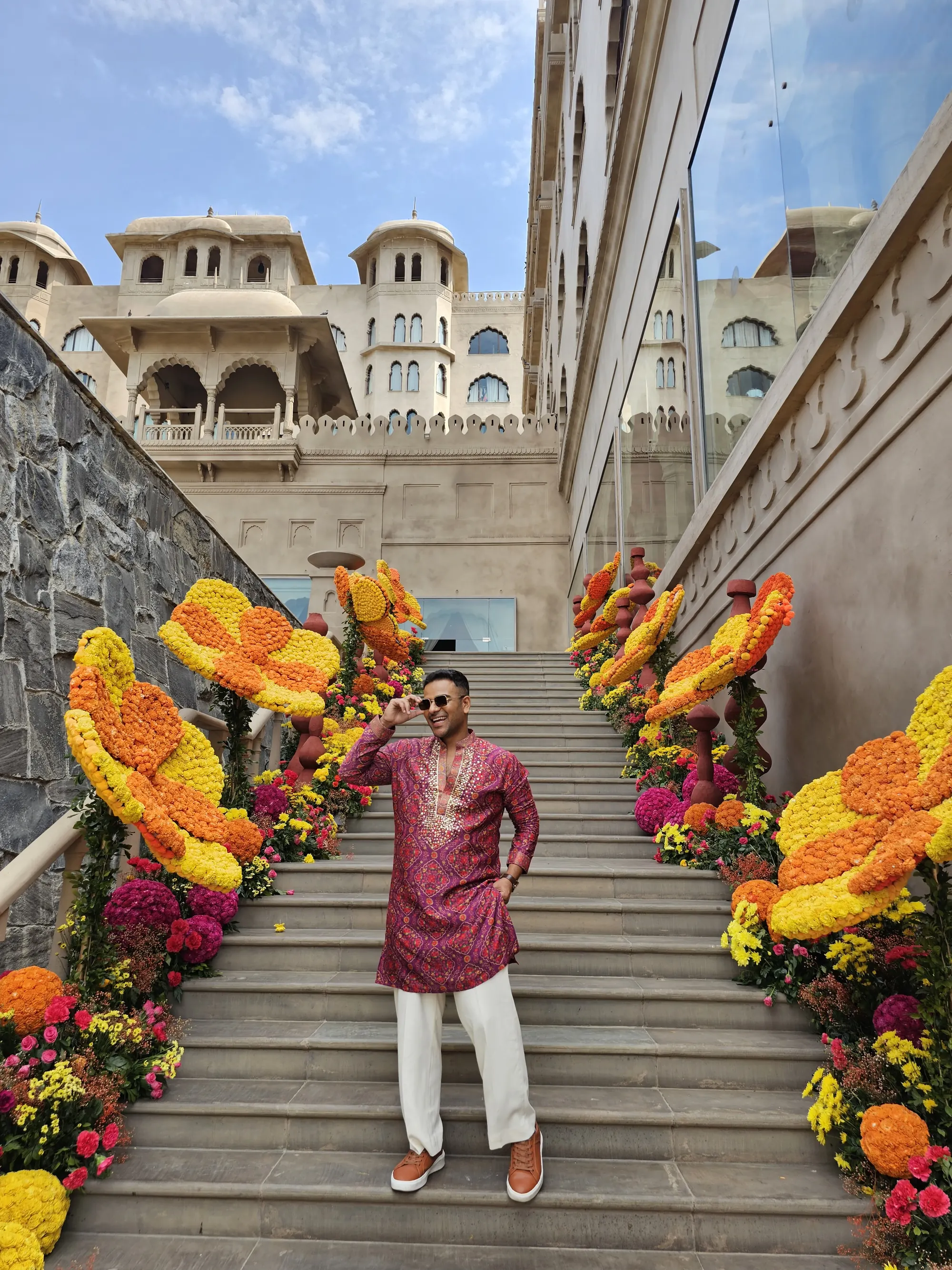 Chirag Vithalani on a staircase lined with marigolds at a palace venue