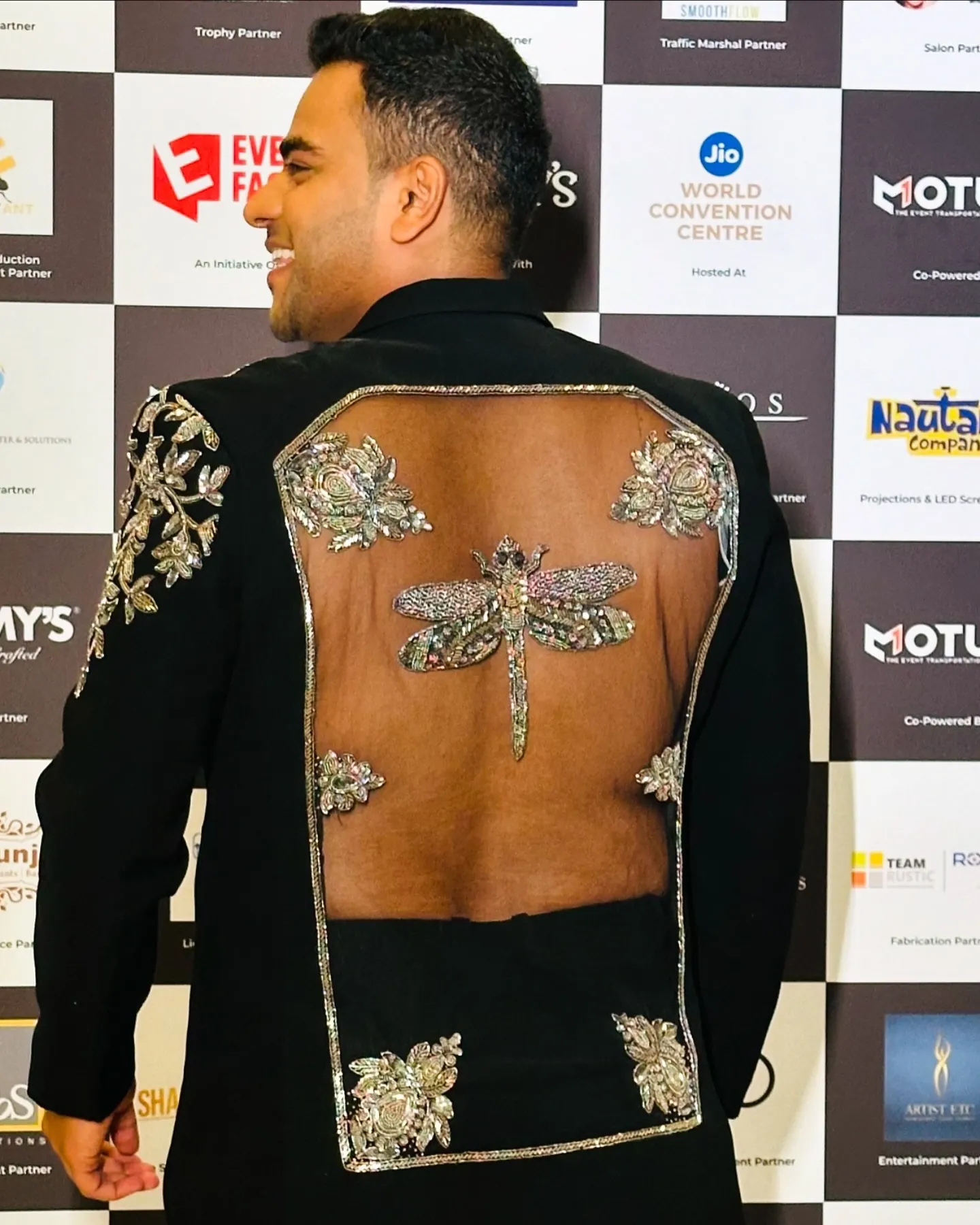 Back of Chirag Vithalani's hand-embroidered dragonfly jacket on a red carpet