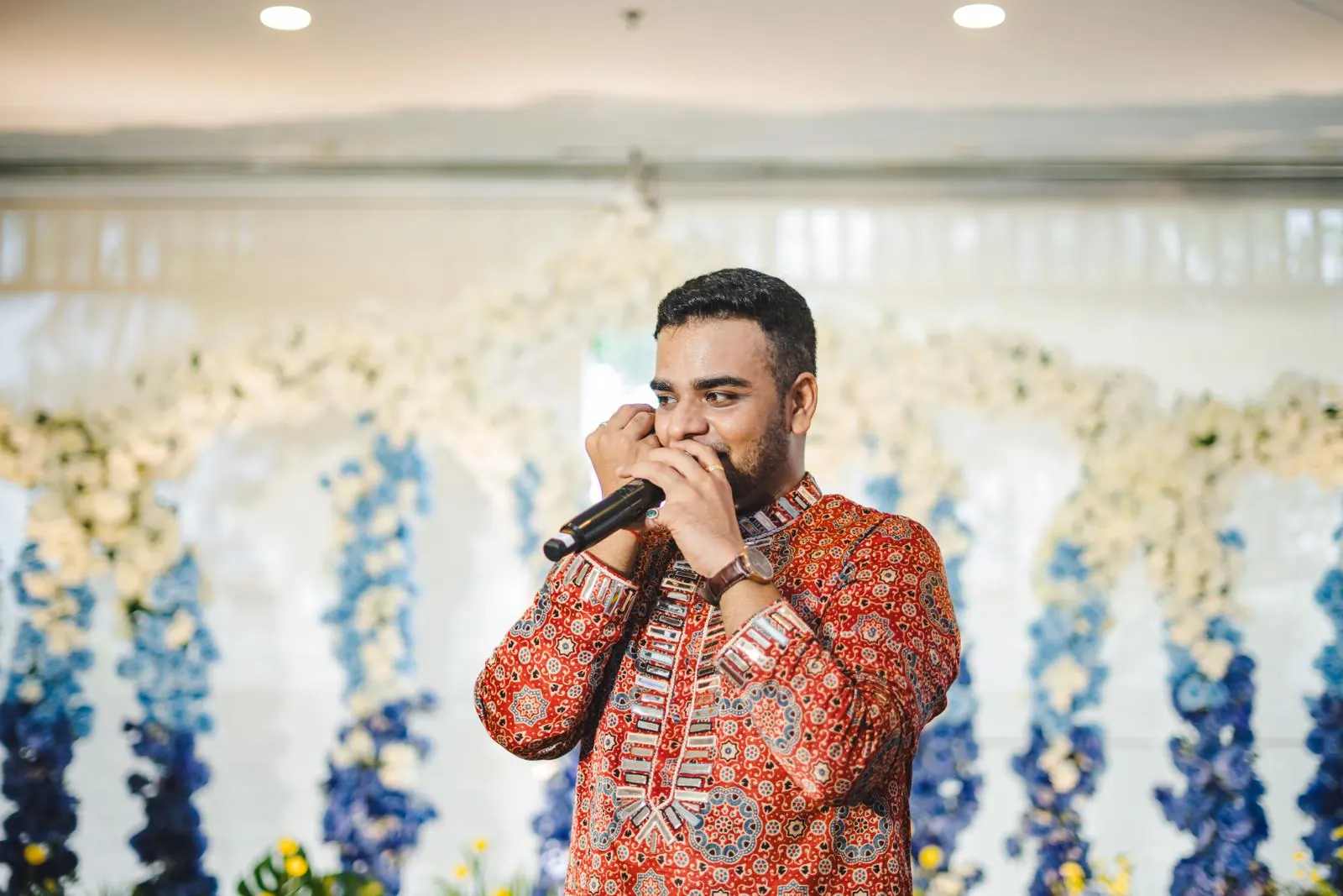 Chirag Vithalani in a printed kurta with the mic at Jenny and Mihir's wedding, Phuket