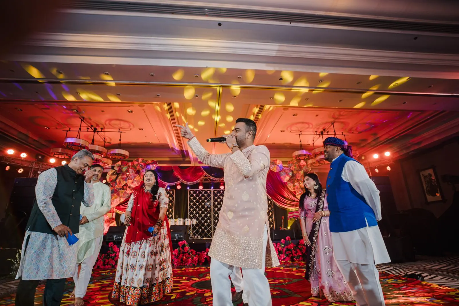 Chirag Vithalani on a red and gold sangeet stage at Jenny and Mihir's wedding, Phuket