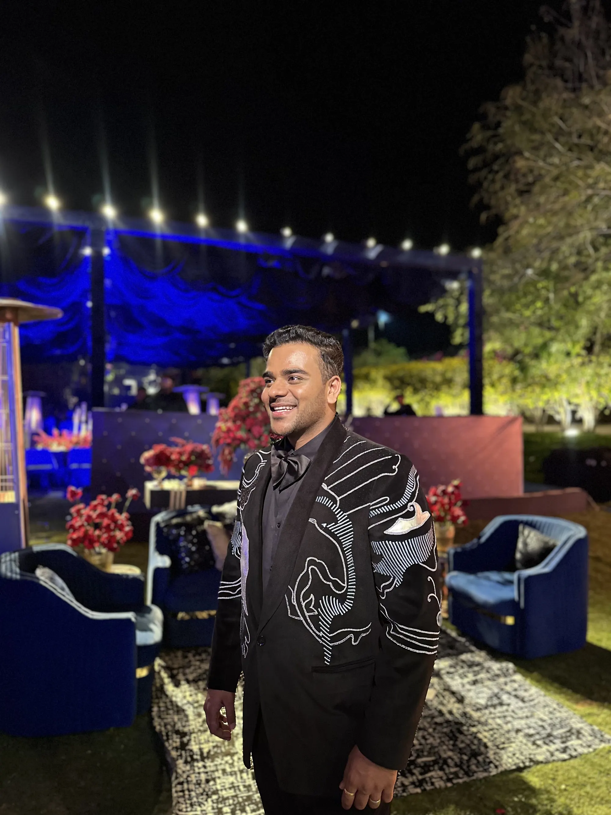 Chirag Vithalani smiling in an embroidered jacket at a night event