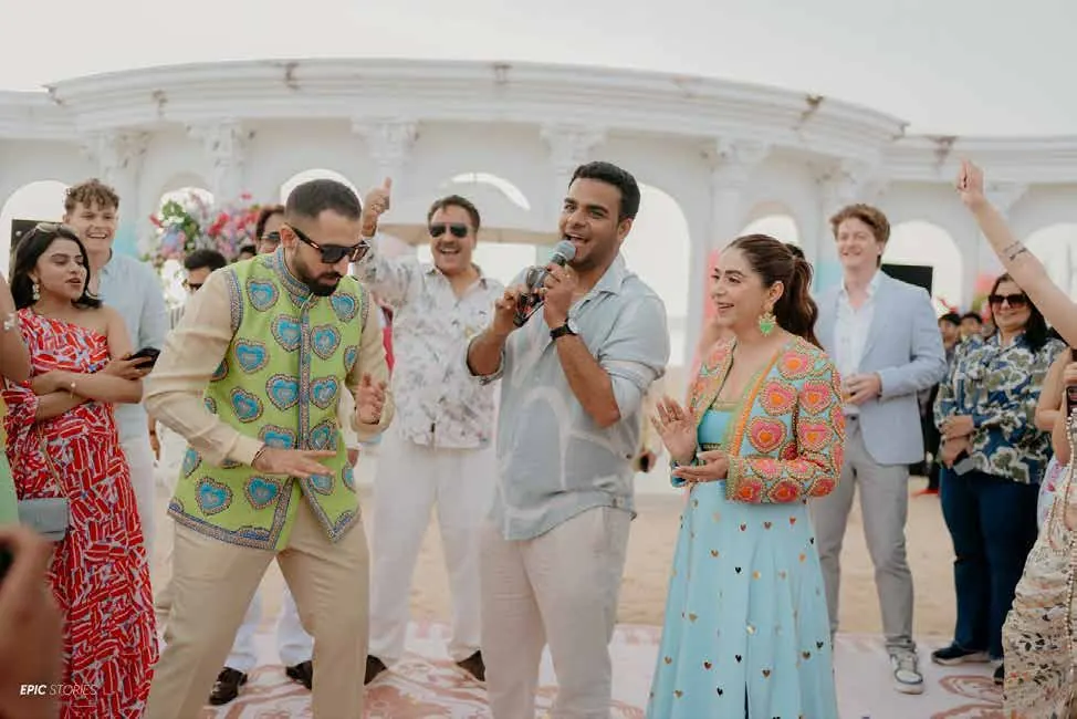 Chirag Vithalani leading guests under white arches at Raj and Sanchi's wedding, Hilton Salwa, Qatar