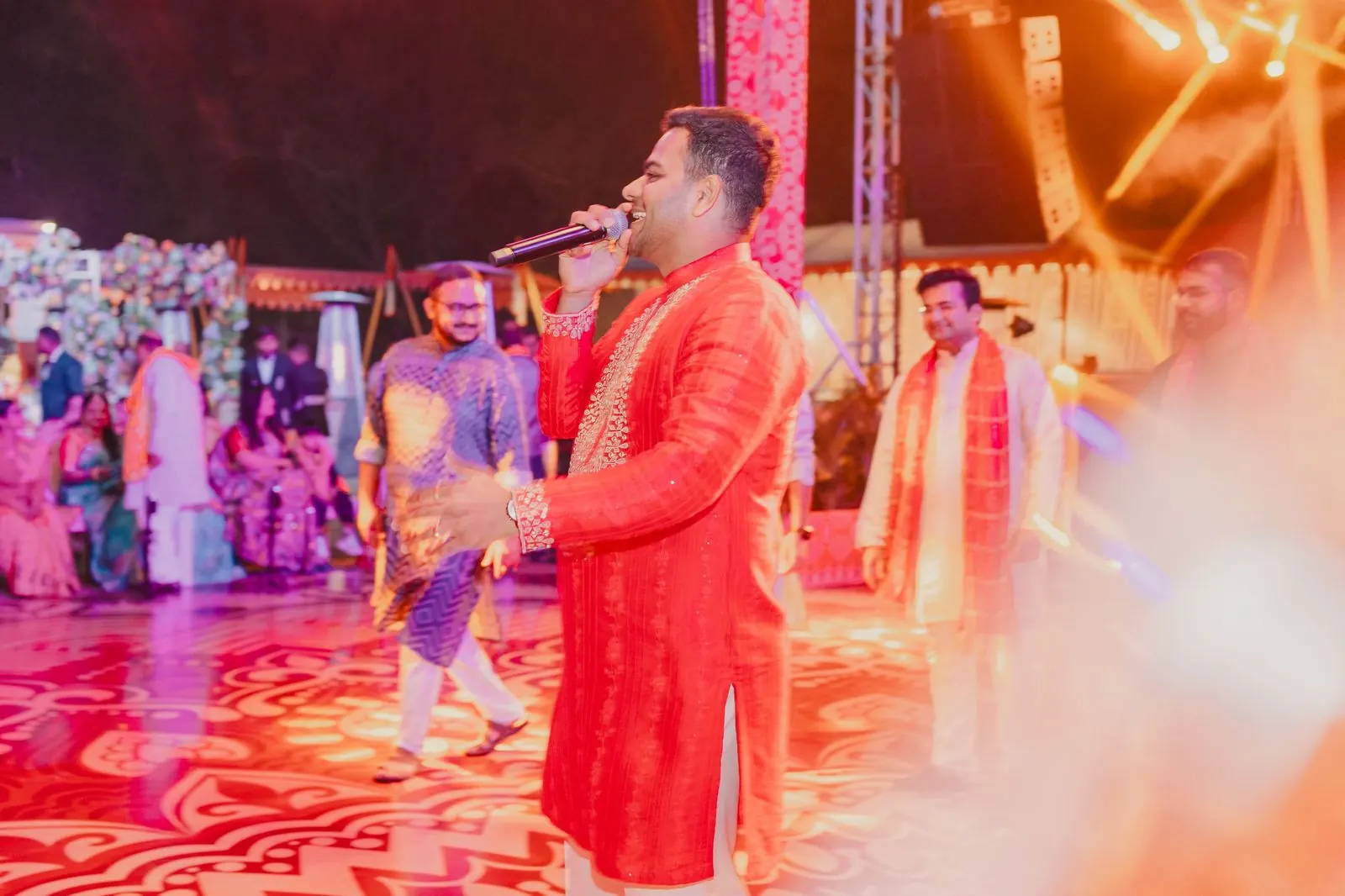 Chirag Vithalani in red on a vivid sangeet stage at Rambagh Palace, Jaipur