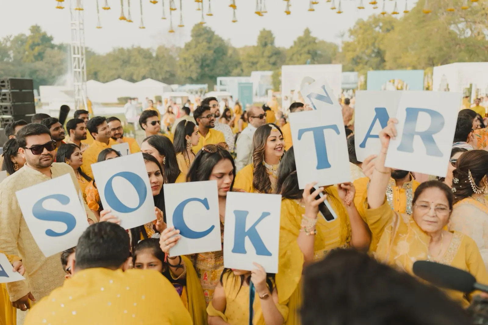 Guests holding up letter signs at Jinali and Harshit's haldi, Rambagh Palace