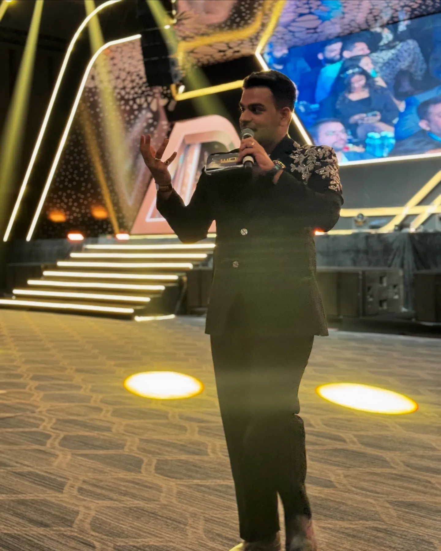 Chirag Vithalani walking a gold-lit awards stage