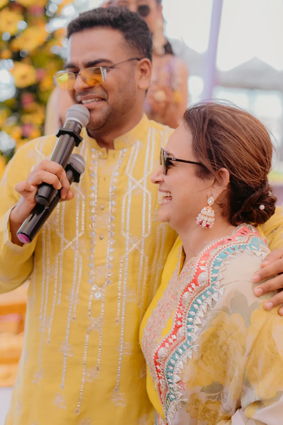 Chirag Vithalani in yellow sharing the mic with family at Dhwani and Vishal's haldi, Tanzania