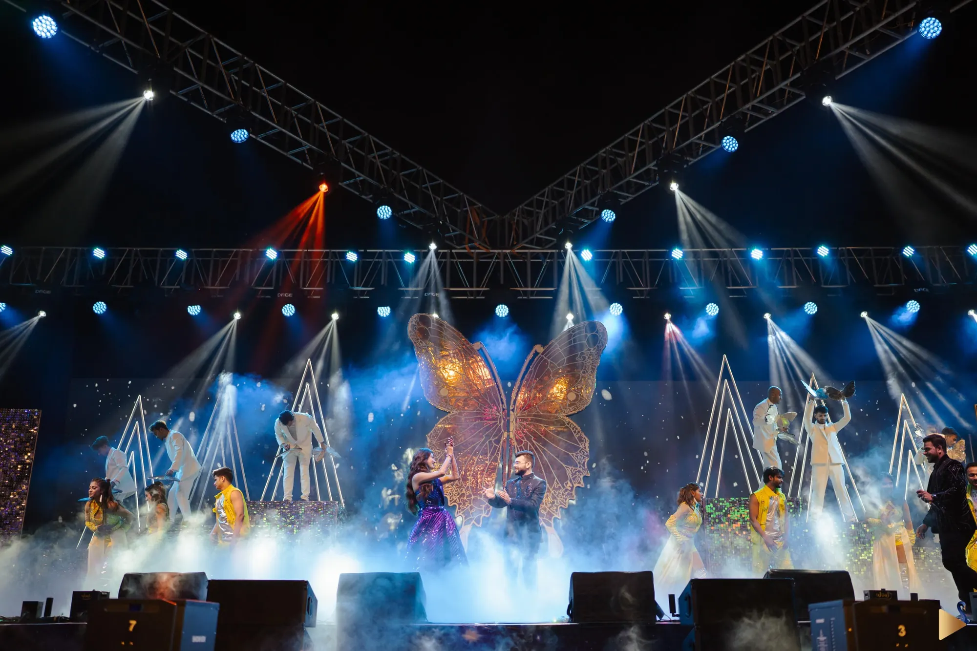 A concert-scale stage with blue light beams at Bartolo and Shivani's sangeet, Udaipur